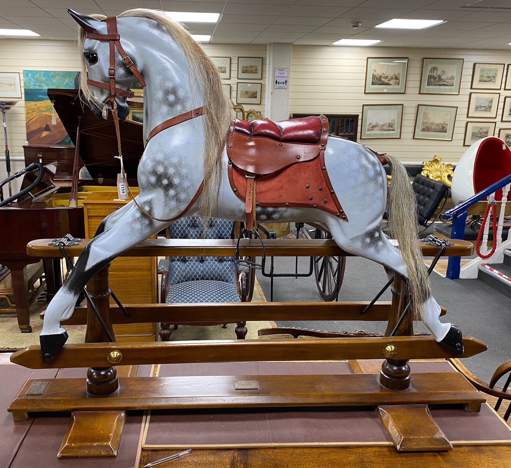 A Stevenson Brothers carved wood dapple grey rocking horse, with burgundy leather tack on beech safety frame, plaque dated 1997 and numbered 2872, length 152cm, height 120cm